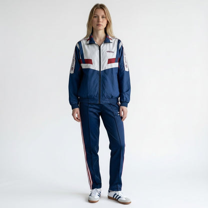 Modelo vistiendo chaqueta deportiva vintage originals vault Adidas con paneles chevron blancos, azules y rojos
